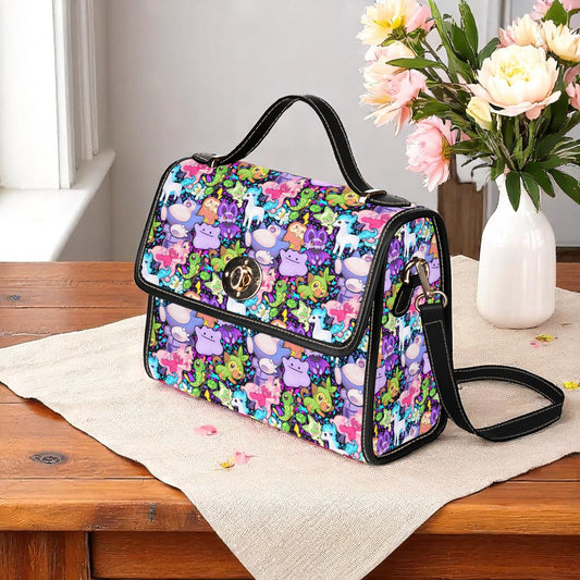 Colourful pocket monster handbag featuring rainbow creatures pattern - adjustable shoulder strap with magnetic closure