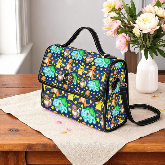 Navy pocket monster handbag featuring starter trio characters with golden stars - adjustable shoulder strap with magnetic closure